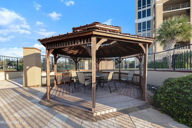 exterior space featuring a gazebo, outdoor dining space, and fence