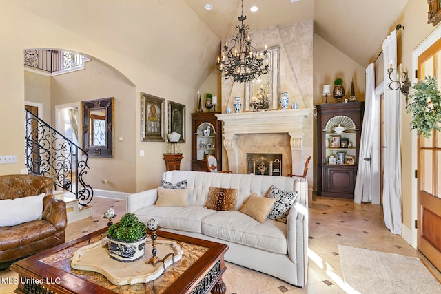 tiled living room with an inviting chandelier, high vaulted ceiling, plenty of natural light, and a tiled fireplace