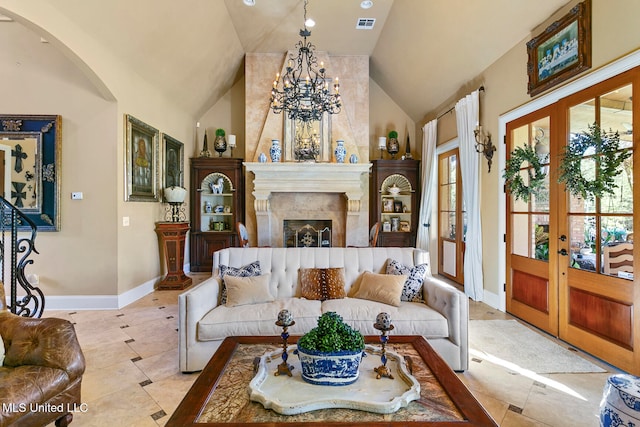 living room with a chandelier, french doors, light tile patterned floors, and high vaulted ceiling