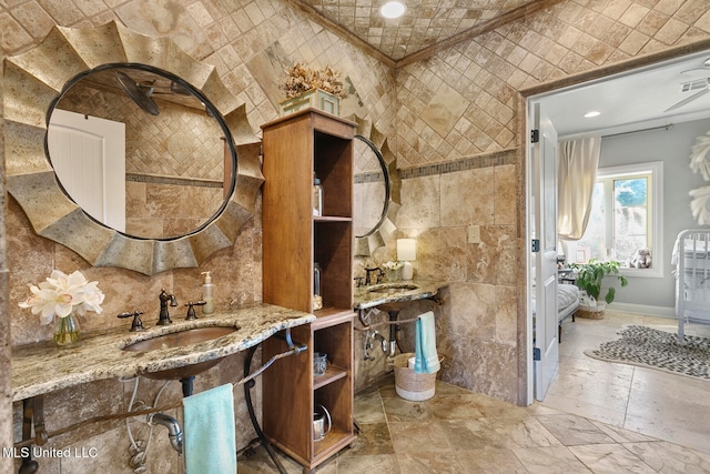 bathroom featuring sink, lofted ceiling, and tile walls