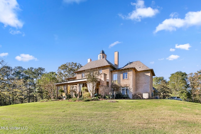 rear view of property with a lawn