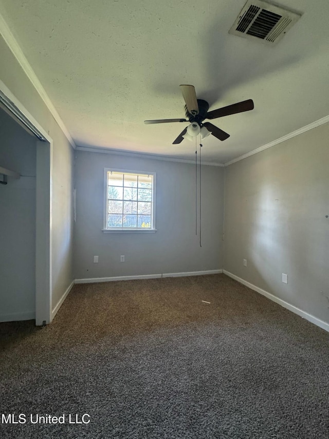 carpeted empty room featuring baseboards, visible vents, and ornamental molding