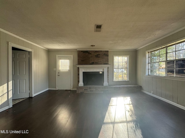 unfurnished living room featuring visible vents, dark wood finished floors, a textured ceiling, crown molding, and a brick fireplace