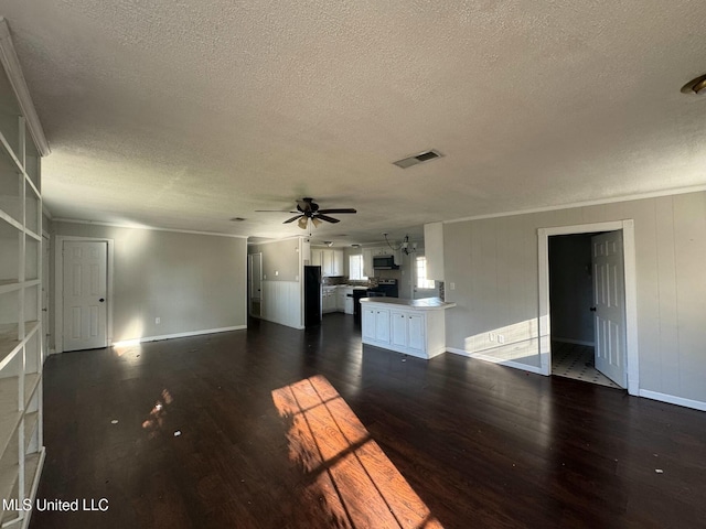 unfurnished living room featuring visible vents, dark wood-type flooring, baseboards, ceiling fan, and a textured ceiling