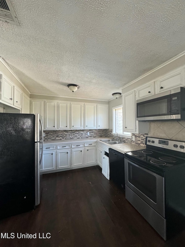 kitchen featuring visible vents, dark wood-style floors, white cabinets, stainless steel appliances, and a sink