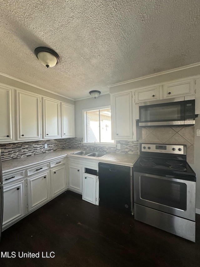 kitchen with a sink, stainless steel appliances, white cabinets, and light countertops