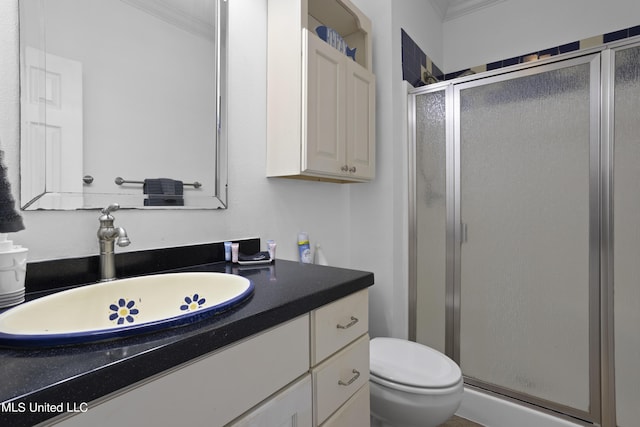 bathroom featuring vanity, an enclosed shower, crown molding, and toilet