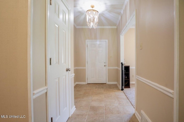 corridor with visible vents, ornamental molding, light tile patterned floors, baseboards, and a chandelier