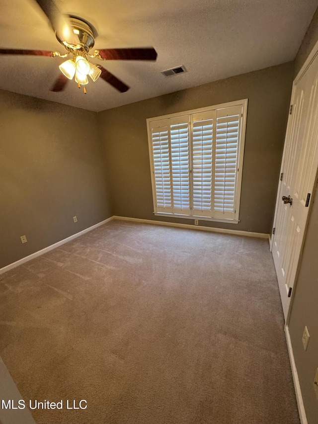 carpeted empty room featuring ceiling fan