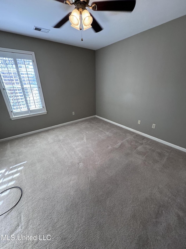 carpeted spare room featuring ceiling fan