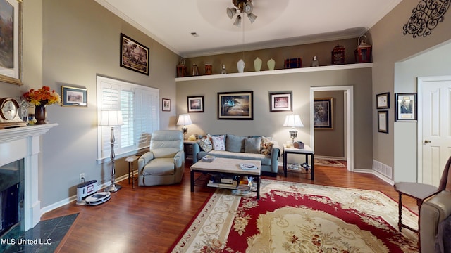 living room featuring dark hardwood / wood-style floors, ceiling fan, ornamental molding, and a high end fireplace