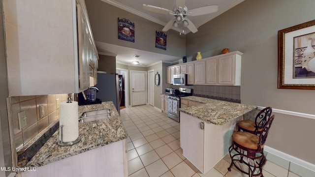 kitchen with sink, a breakfast bar area, decorative backsplash, ornamental molding, and stainless steel appliances