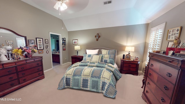 bedroom with connected bathroom, ceiling fan, light colored carpet, and vaulted ceiling