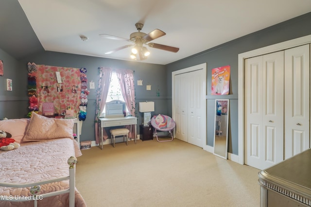 bedroom with two closets, ceiling fan, and carpet