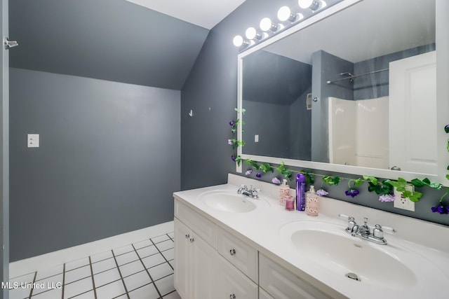 bathroom featuring tile patterned flooring, vanity, lofted ceiling, and a shower