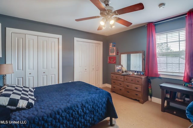 carpeted bedroom with multiple closets and ceiling fan