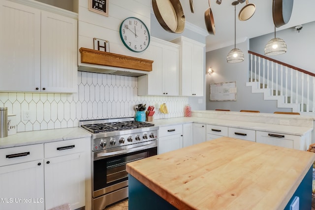 kitchen featuring white cabinetry, hanging light fixtures, stainless steel range, a kitchen island, and decorative backsplash