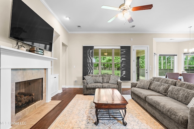 5110 Kensington Creek Dr, Southaven, MS 38672 - living room with wood finished floors, ceiling fan, crown molding, a chandelier, and a tiled fireplace
