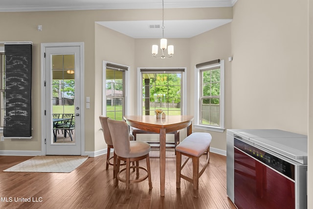 5110 Kensington Creek Dr, Southaven, MS 38672 - dining area with beverage cooler, wood finished floors, a chandelier, and ornamental molding