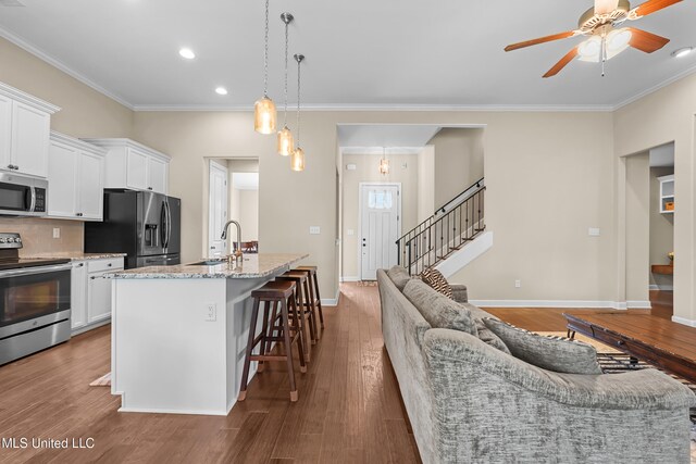 5110 Kensington Creek Dr, Southaven, MS 38672 - kitchen featuring stainless steel appliances, crown molding, a kitchen breakfast bar, a ceiling fan, and white cabinetry