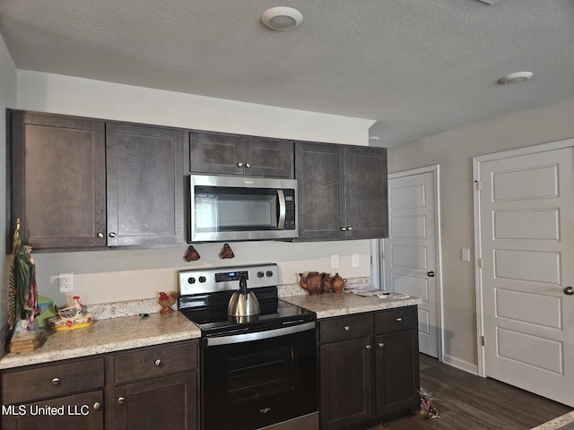 2205 Magazine St, Ocean Springs, MS 39564 - kitchen with appliances with stainless steel finishes, dark wood finished floors, light countertops, dark brown cabinetry, and a textured ceiling