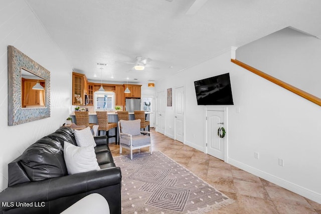 living room featuring ceiling fan and baseboards