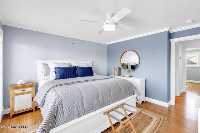 bedroom featuring ceiling fan, crown molding, baseboards, and wood finished floors