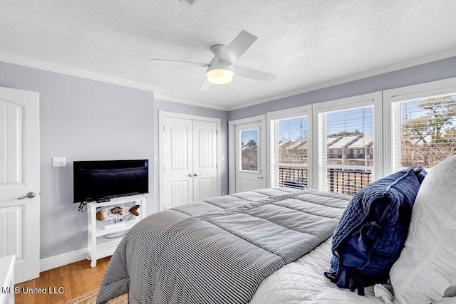 bedroom with crown molding, multiple windows, a closet, and wood finished floors