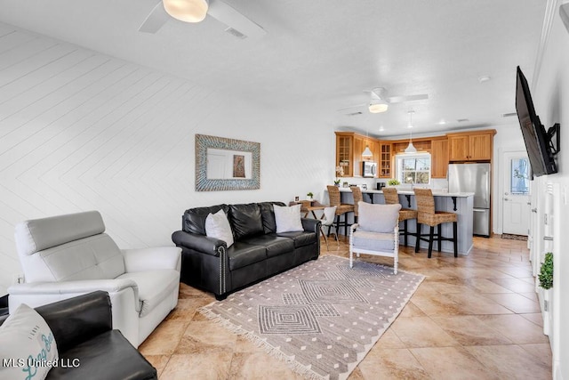 living room with ceiling fan and visible vents