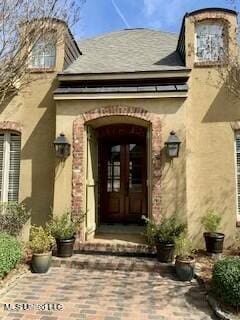 entrance to property with french doors and stucco siding