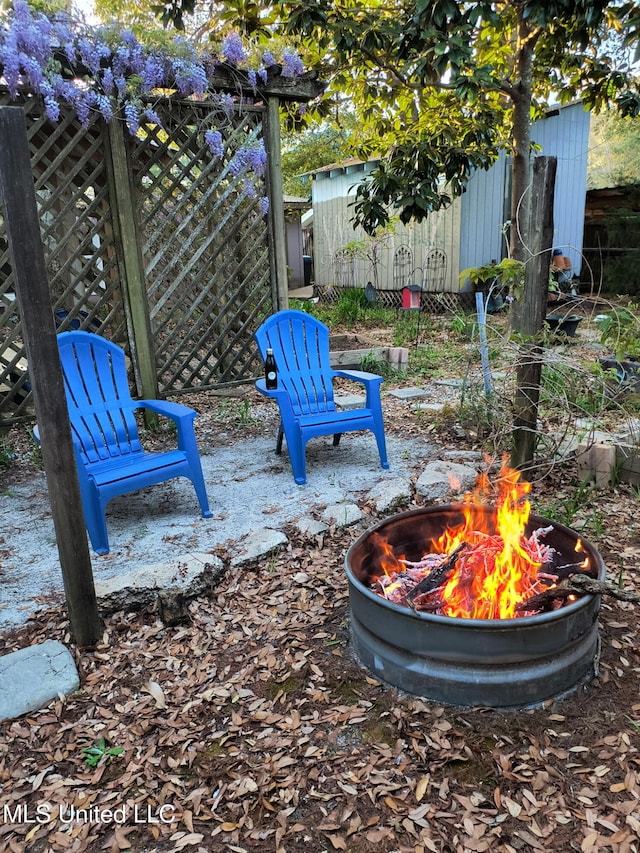 view of yard with an outdoor fire pit, an outbuilding, and fence