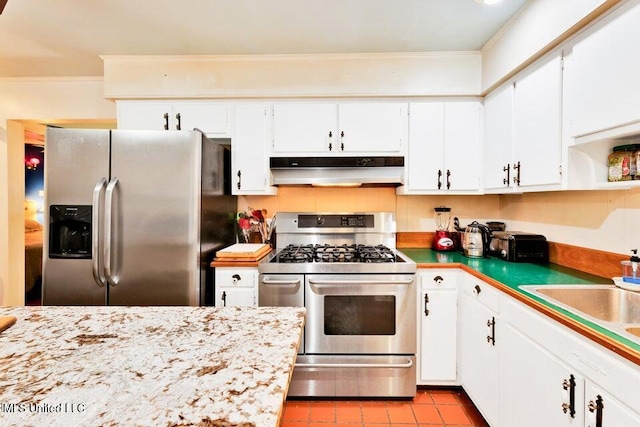 kitchen with light tile patterned floors, stainless steel appliances, white cabinetry, and sink