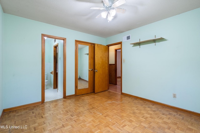 unfurnished bedroom featuring ceiling fan, light parquet flooring, and ensuite bath