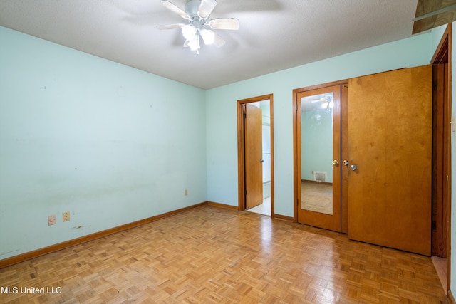 unfurnished bedroom featuring ceiling fan, light parquet flooring, and a textured ceiling