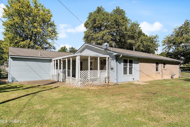 back of property with a yard and covered porch