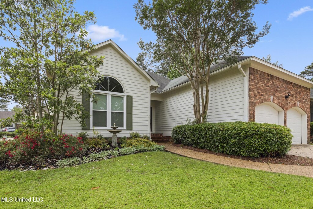 231 Bayview Dr, Madison, MS 39110 - ranch-style house featuring a garage, a front lawn, brick siding, concrete driveway, and roof with shingles