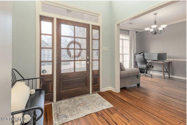 entrance foyer with wood-type flooring, crown molding, and an inviting chandelier