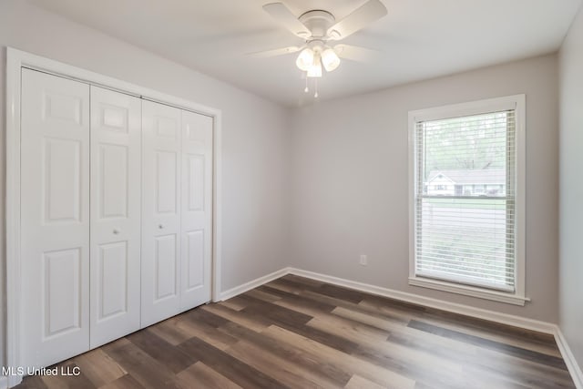 12082 Marlane Pl, Gulfport, MS 39503 - unfurnished bedroom featuring dark wood-type flooring, a closet, baseboards, and multiple windows