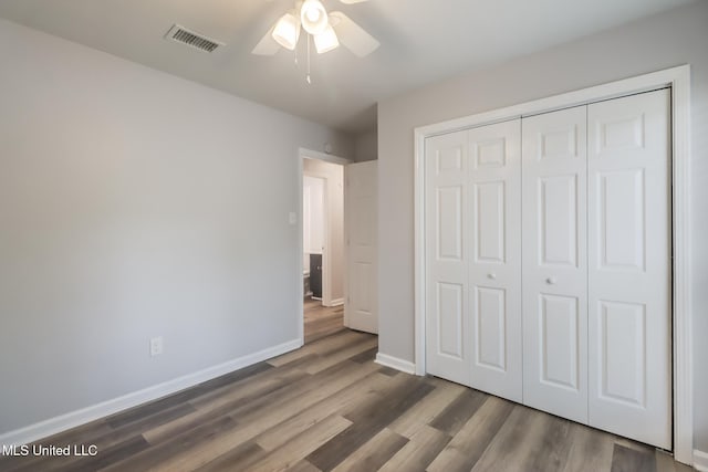 12082 Marlane Pl, Gulfport, MS 39503 - unfurnished bedroom with a closet, visible vents, baseboards, wood finished floors, and a ceiling fan