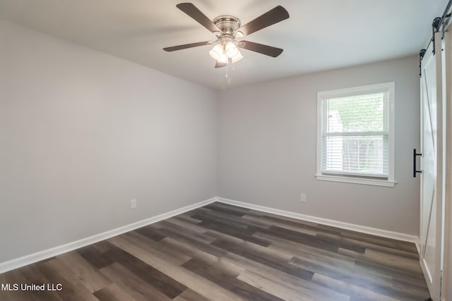 12082 Marlane Pl, Gulfport, MS 39503 - empty room with baseboards, a barn door, ceiling fan, and dark wood finished floors
