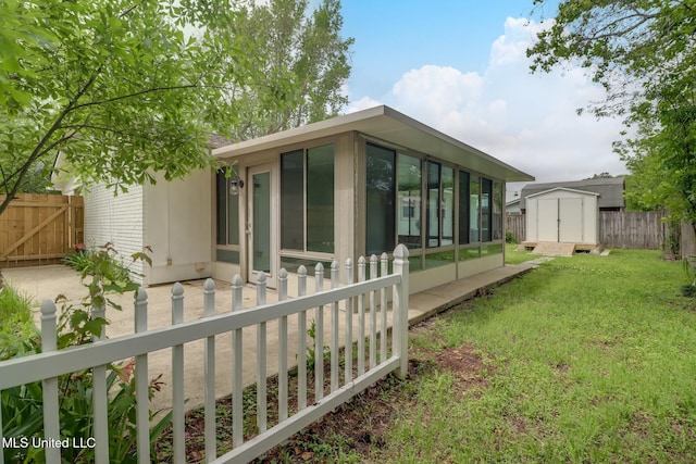 12082 Marlane Pl, Gulfport, MS 39503 - rear view of property featuring a sunroom, fence, a lawn, an outbuilding, and a shed