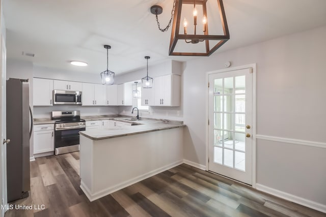 12082 Marlane Pl, Gulfport, MS 39503 - kitchen with white cabinetry, dark wood-style flooring, appliances with stainless steel finishes, and a peninsula