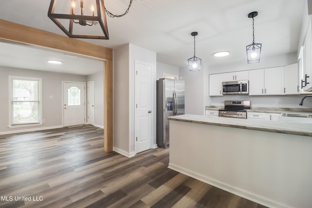 12082 Marlane Pl, Gulfport, MS 39503 - kitchen featuring white cabinetry, dark wood finished floors, a sink, light stone counters, and appliances with stainless steel finishes