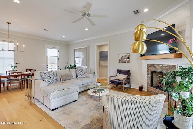 122 Seymour Dr, Madison, MS 39110 - living room with light wood finished floors, a chandelier, ornamental molding, a fireplace, and ceiling fan
