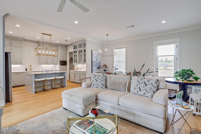 122 Seymour Dr, Madison, MS 39110 - living area with plenty of natural light, light wood-style floors, a chandelier, crown molding, and ceiling fan