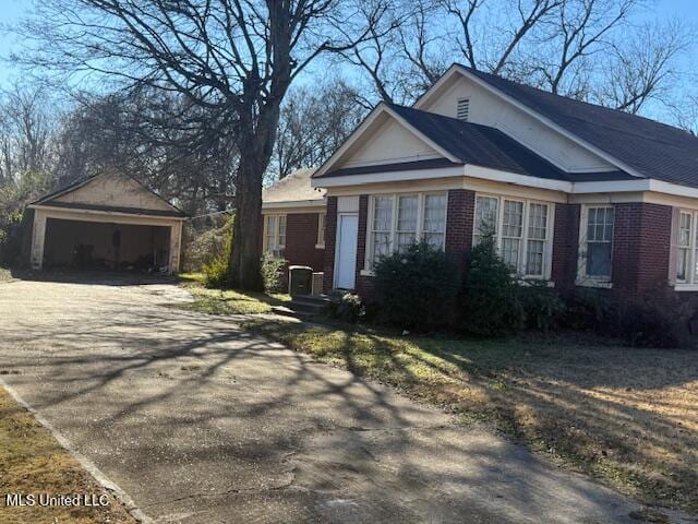 view of front of home featuring a garage and an outbuilding