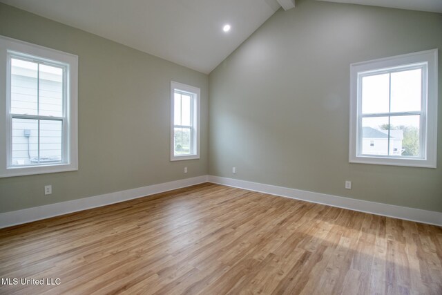 103 E 2nd St, Pass Christian, MS 39571 - empty room featuring light wood-style flooring, a healthy amount of sunlight, baseboards, and vaulted ceiling