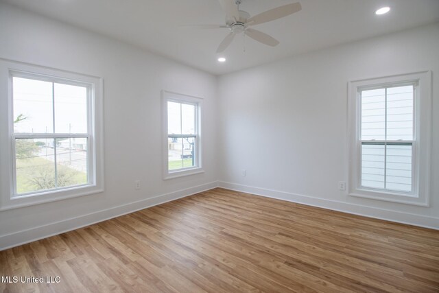 103 E 2nd St, Pass Christian, MS 39571 - empty room with light wood-style flooring, a wealth of natural light, and baseboards