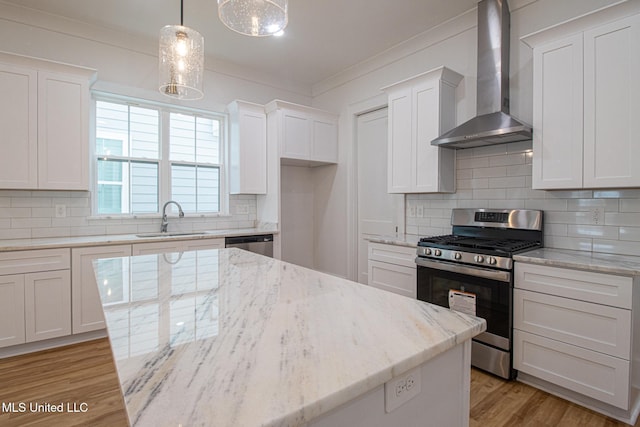 103 E 2nd St, Pass Christian, MS 39571 - kitchen featuring light wood-style floors, wall chimney range hood, ornamental molding, appliances with stainless steel finishes, and a sink