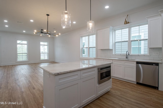 103 E 2nd St, Pass Christian, MS 39571 - kitchen featuring decorative backsplash, a sink, ornamental molding, and appliances with stainless steel finishes